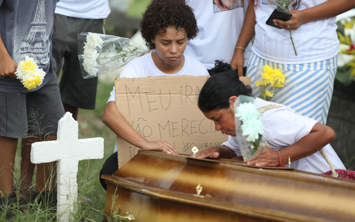 Enterro de Uesclei da Silva Estácio, de 29 anos, morto por um tiro na cabeça quando voltava para casa, na Comunidade do Tirol, na Freguesia. No cemitério de Inhaúma. Na foto, a irmã Suelen Batista (cabelo curto) e a mãe Sueli Batista sobre o caixão. - Pedro Ivo/ Agência O Dia
