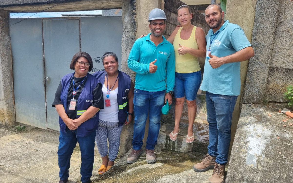 A moradora Val&eacute;ria Tundela com a equipe da &Aacute;guas do Rio que atua na Baixada Fluminense