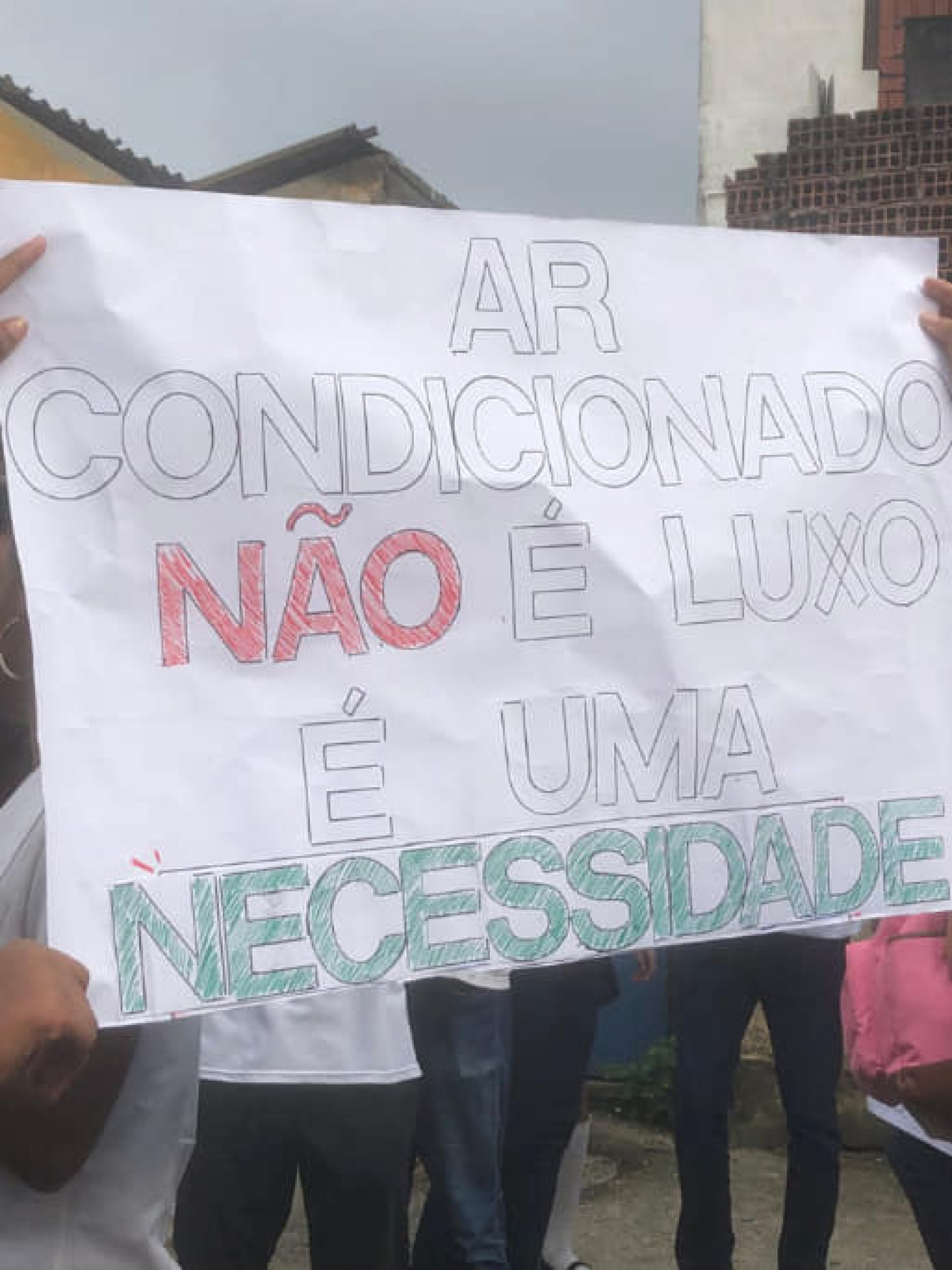 Alunos com cartazes destacando a import&acirc;ncia do ar-condicionado nas salas de aulas - Reprodu&ccedil;&atilde;o / Redes Sociais