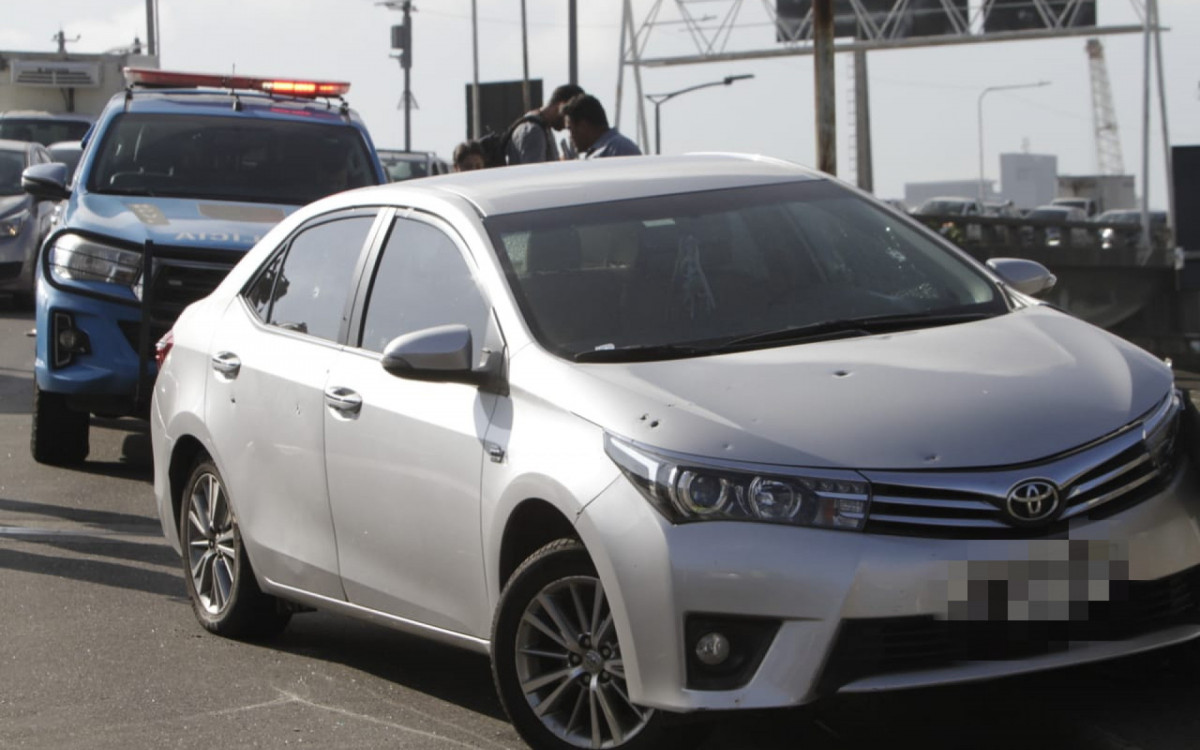 Carro da v&iacute;tima ficou com diversas marcas de tiros ap&oacute;s o crime
