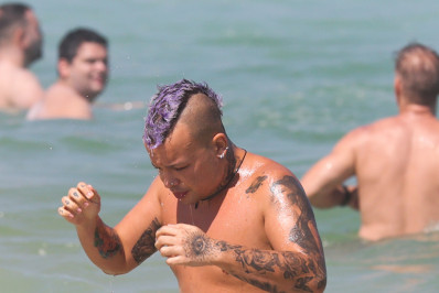 Sem a parte de cima do biquíni, Daniel Garcia, a Gloria Groove, curte dia de sol no Rio