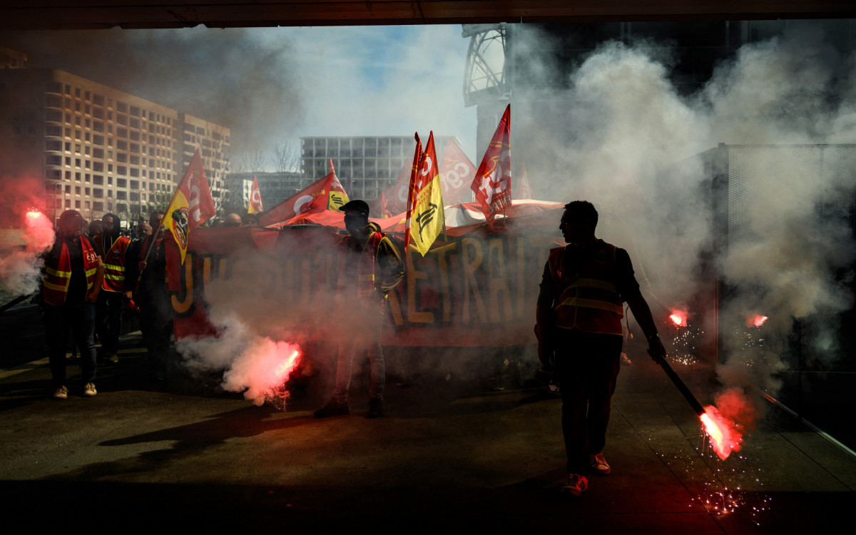 FRANCE-POLITICS-GOVERNMENT-PENSIONS-DEMO
A protester lights a flare as railway workers demonstrate a few days after the government pushed a pensions reform through parliament without a vote, using the article 49.3 of the constitution in Lyon on March 22, 2023. French President defiantly vowed to push through a controversial pensions reform, saying he was prepared to accept unpopularity in the face of someti - JEFF PACHOUD / AFP