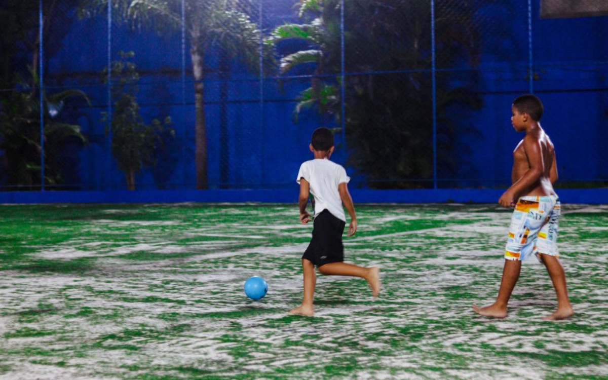 A garotada no campo de grama sint&eacute;tica