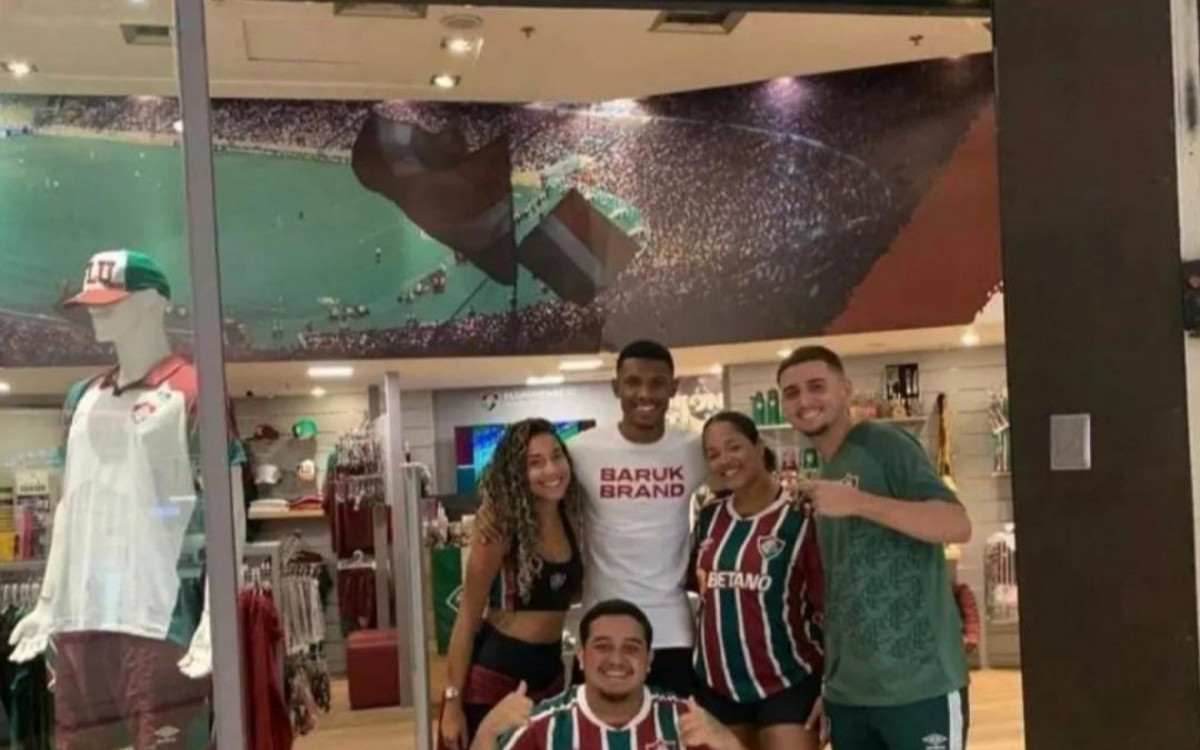 Lel&ecirc; em frente a uma loja do Fluminense