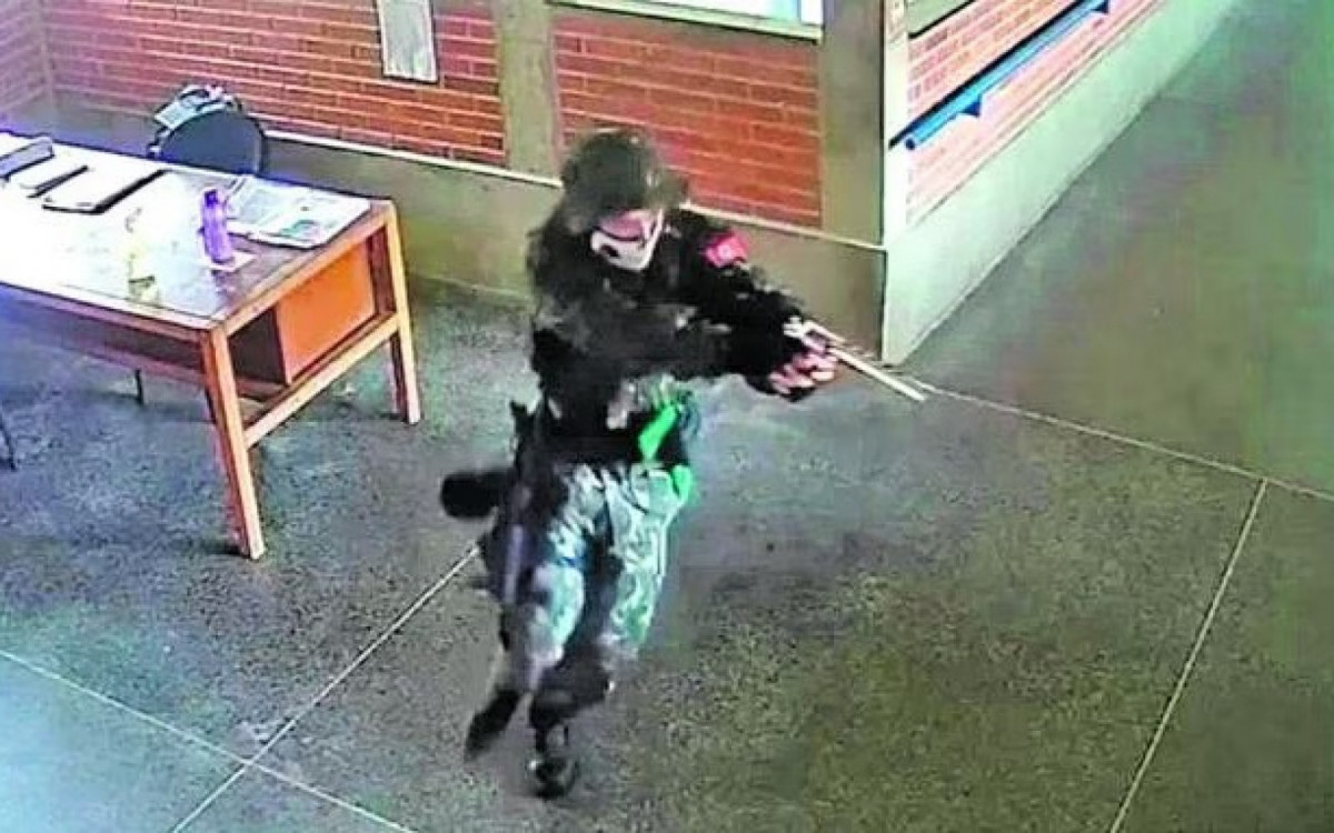 Estudante com uma su&aacute;stica no bra&ccedil;o correndo para efetuar disparos no Esp&iacute;rito Santo