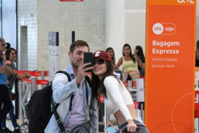 Vitória Strada posa sorridente com fã em aeroporto do Rio