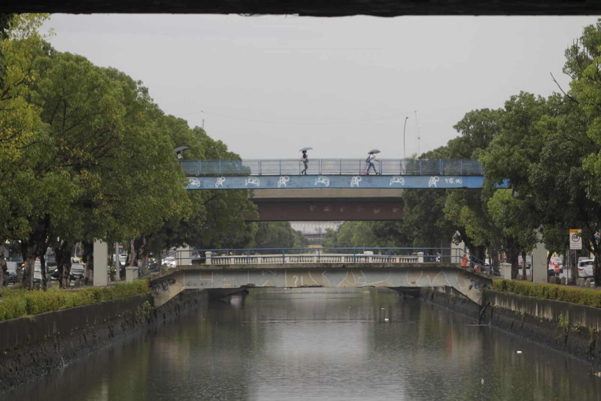 Cariocas se protegem da chuva desta quarta-feira ao passar pela Avenida Francisco Bicalho, na Leopoldina - Reginaldo Pimenta/Ag&ecirc;ncia O Dia