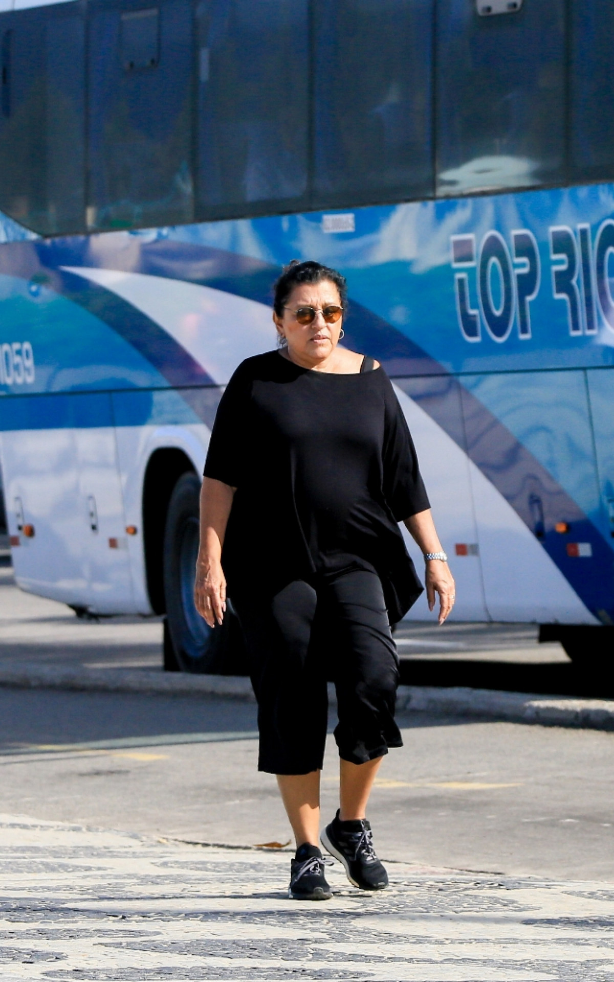 Regina Casé caminha na orla de Ipanema, na Zona Sul do Rio