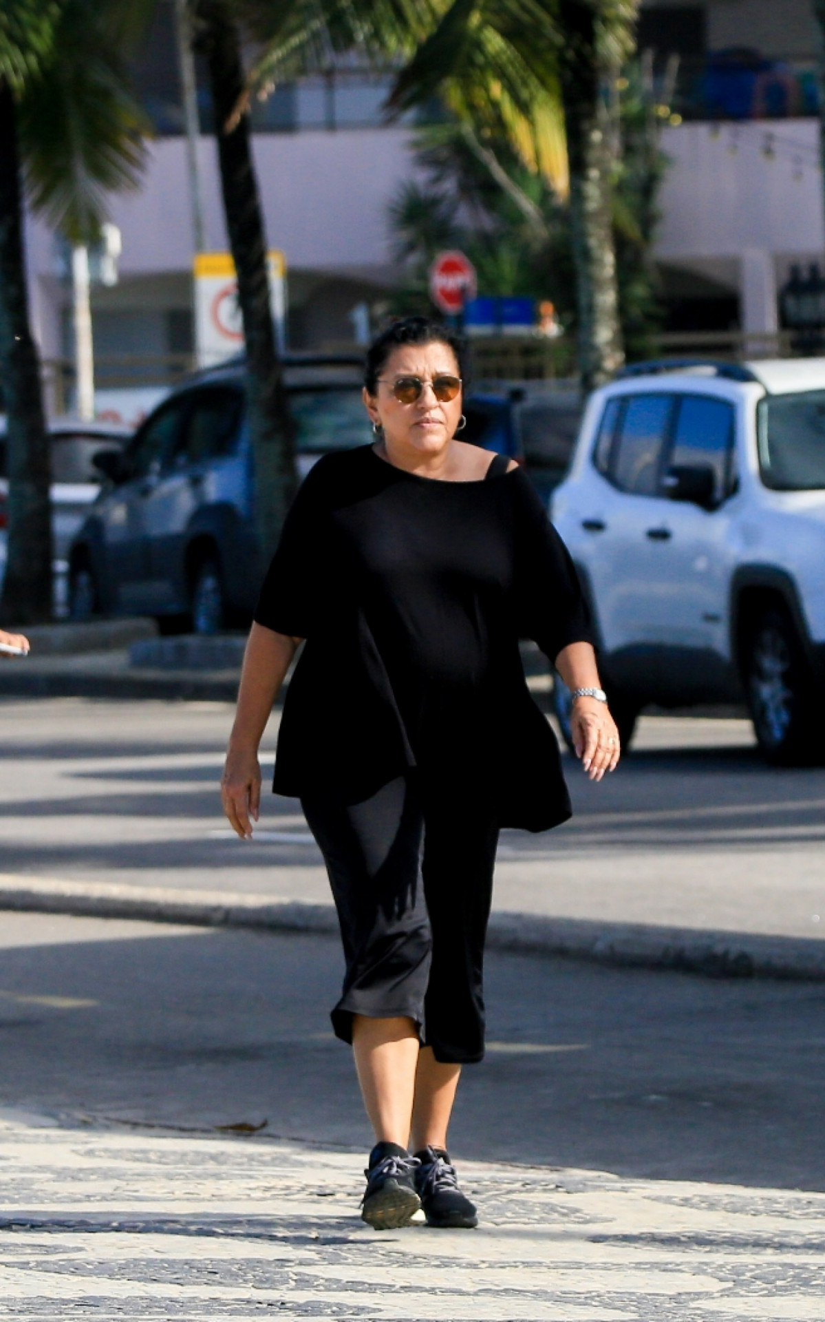 Regina Casé caminha na orla de Ipanema, na Zona Sul do Rio