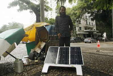 Morador em situação de rua utiliza placas de energia solar para realizar consertos de celulares