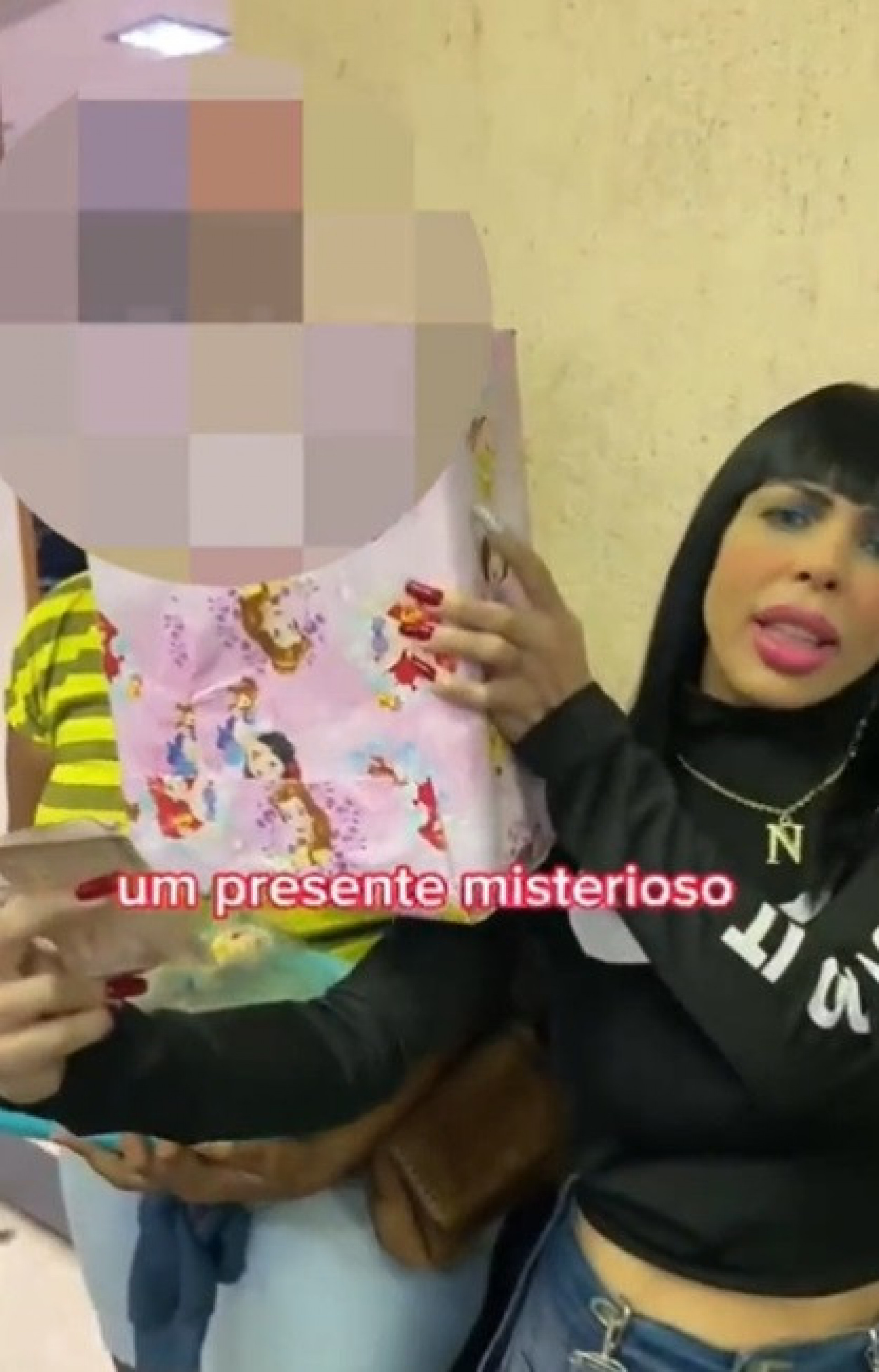 Influenciadora Kérollen Cunha aparece em novo vídeo entregando uma banana amassada dentro de uma carteira para uma mulher negra - Reprodução