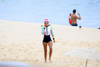 Toda equipada, Taís Araújo dá mergulho no mar de Ipanema