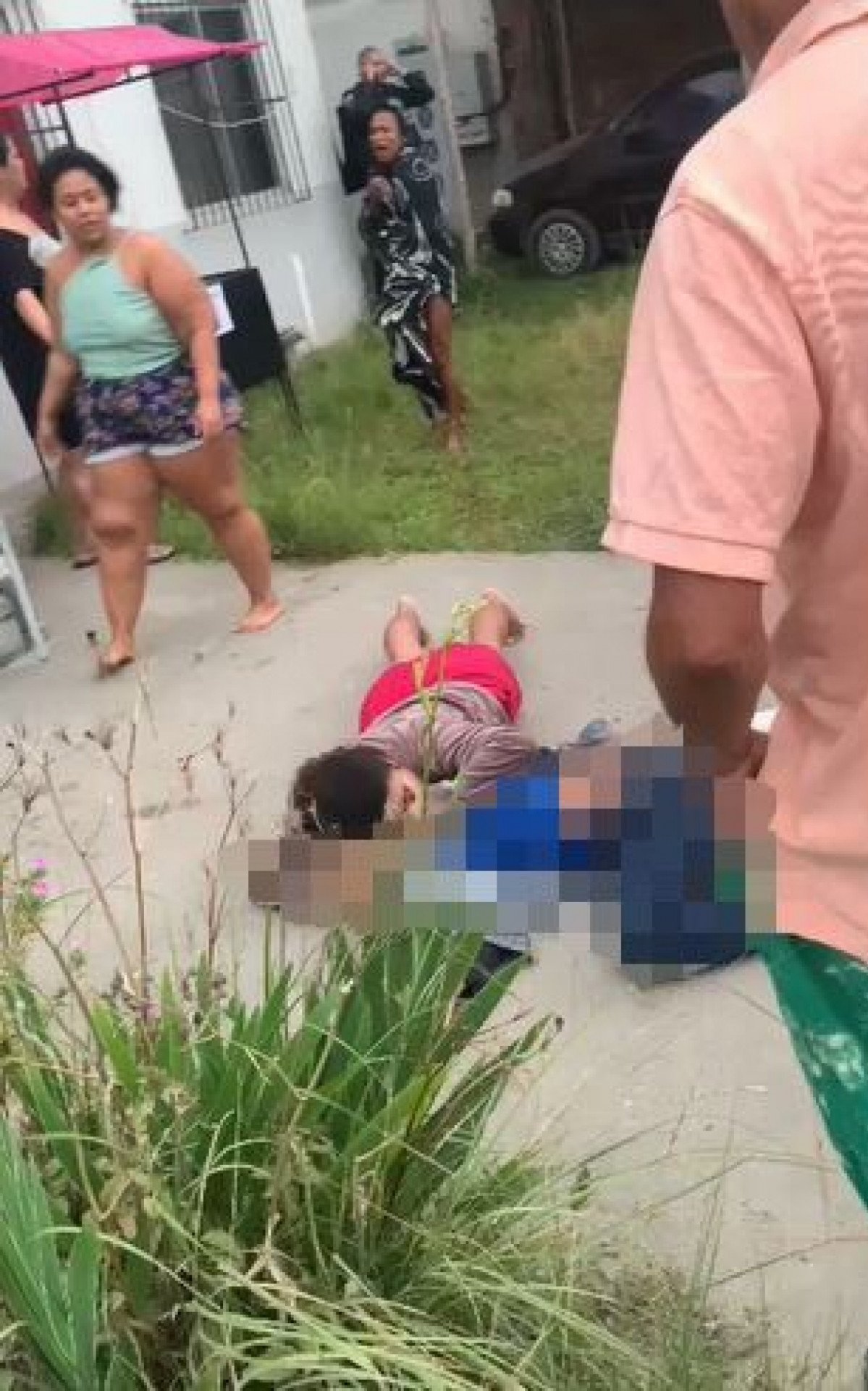 Na imagem, um mulher deita ao lado da criança e lamenta a morte - Rede Social