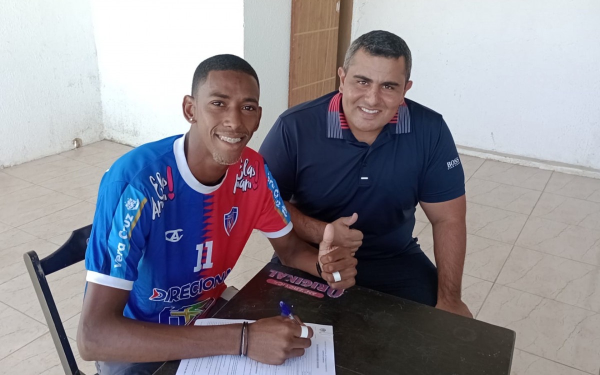 O centroavante Patrick Andrade (E) assinando o contrato com o presidente de Honra da SEBR, Rodrigo Gomes