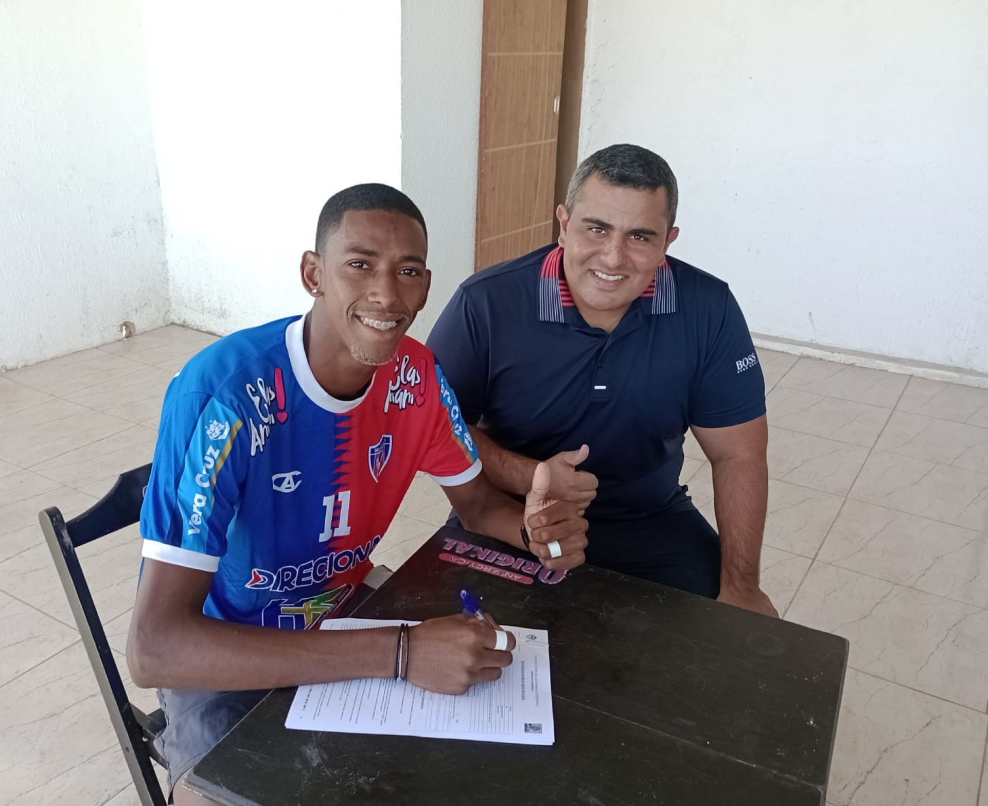 O centroavante Patrick Andrade (E) assinando o contrato com o presidente de Honra da SEBR, Rodrigo Gomes - Divulgação
