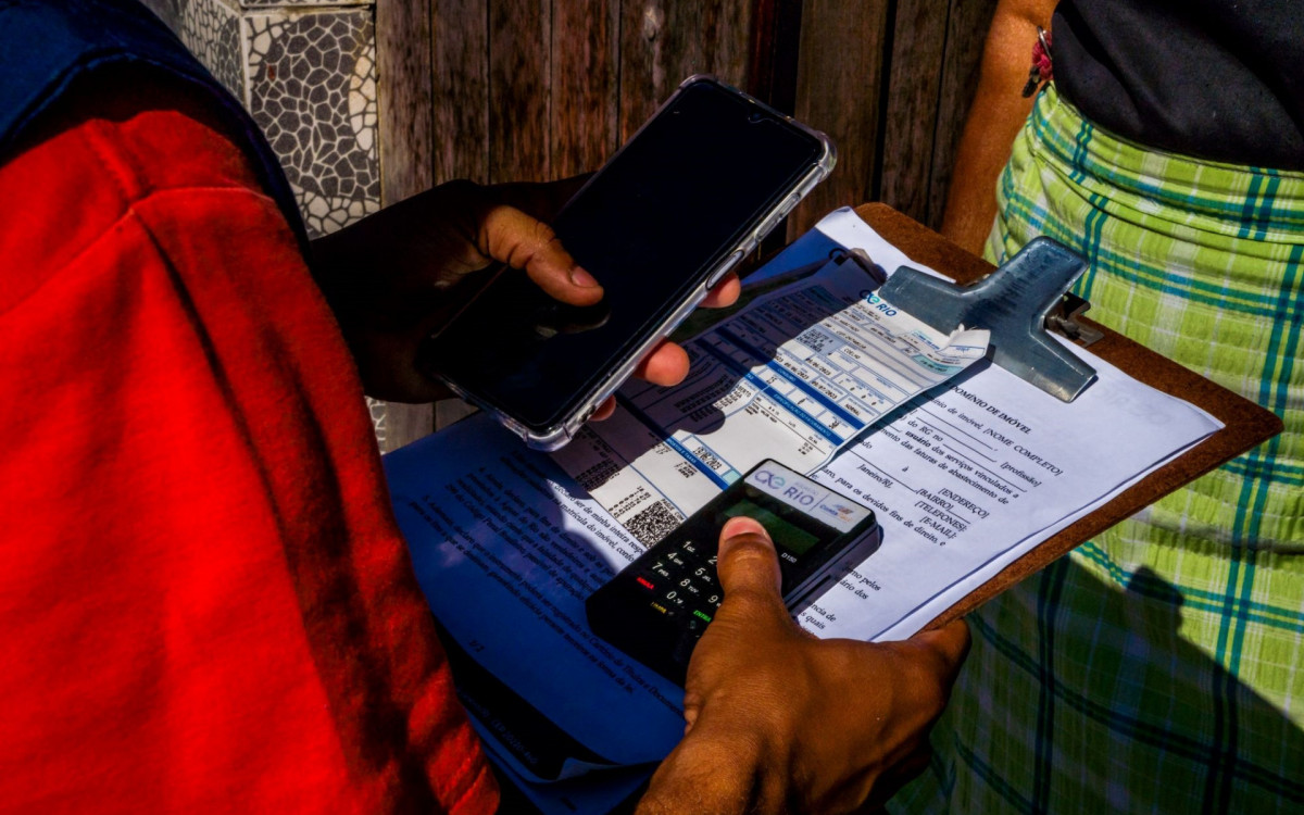 Os profissionais da Águas do Rio carregam uma maquininha de débito e crédito personalizada com a logo da empresa
