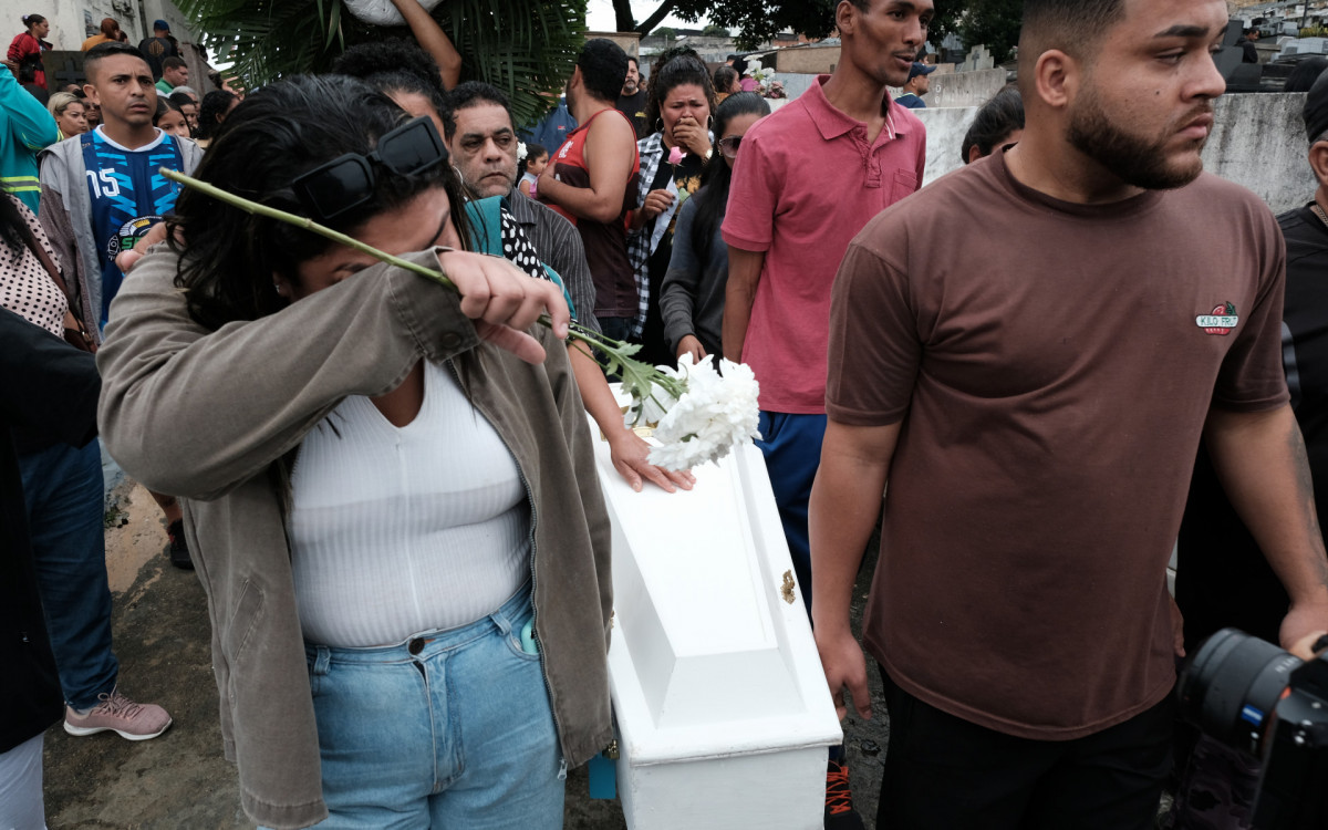 Caixão branco com o corpo da menina é carregado em meio a muita emoção e revolta no Cemitério do Cacuia, na Ilha do Governador