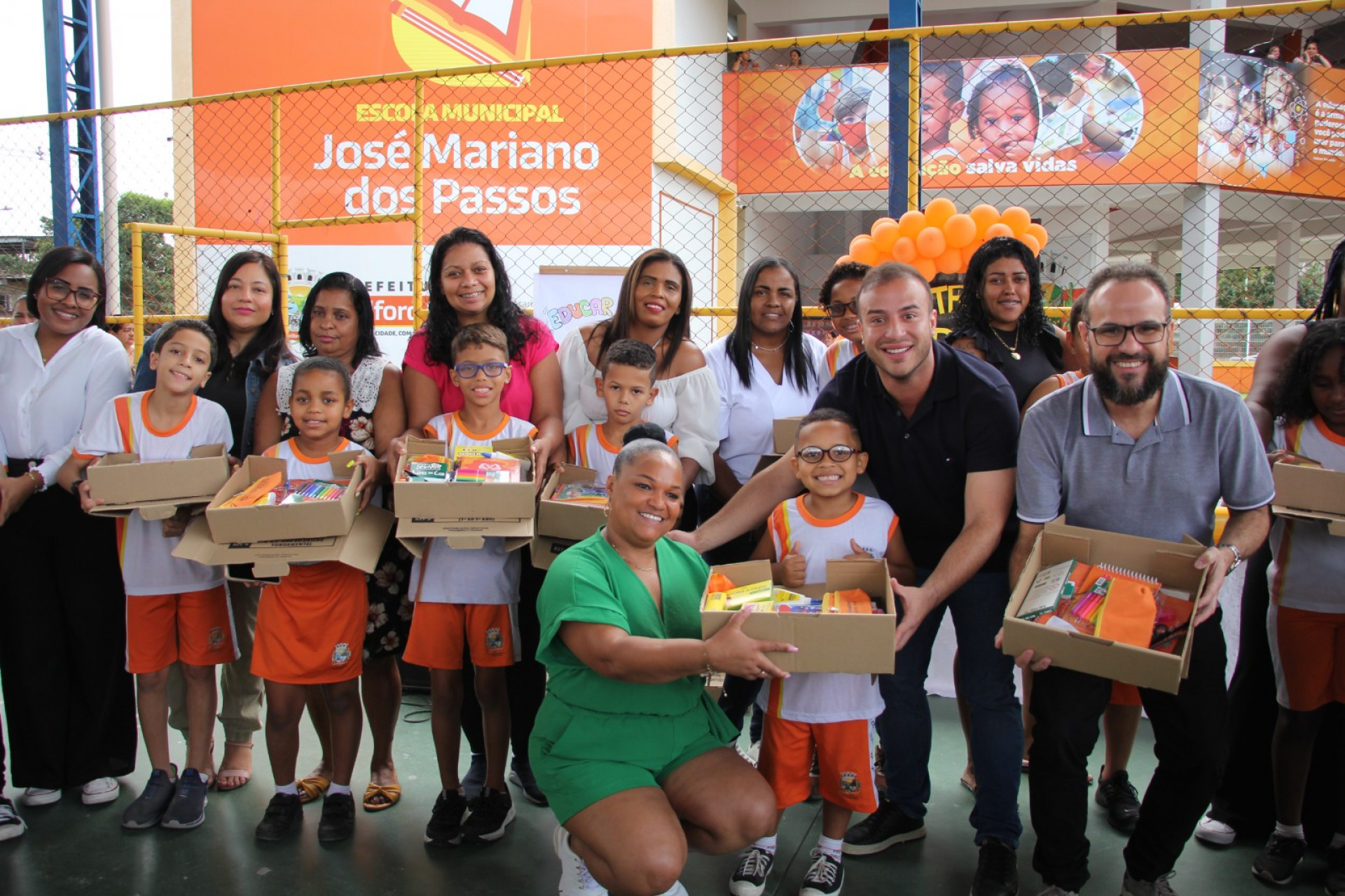 Matheus Carneiro e Denis Macedo com alunos e respons&aacute;veis na entrega de kits escolares - Kristian Amarante/PMBR