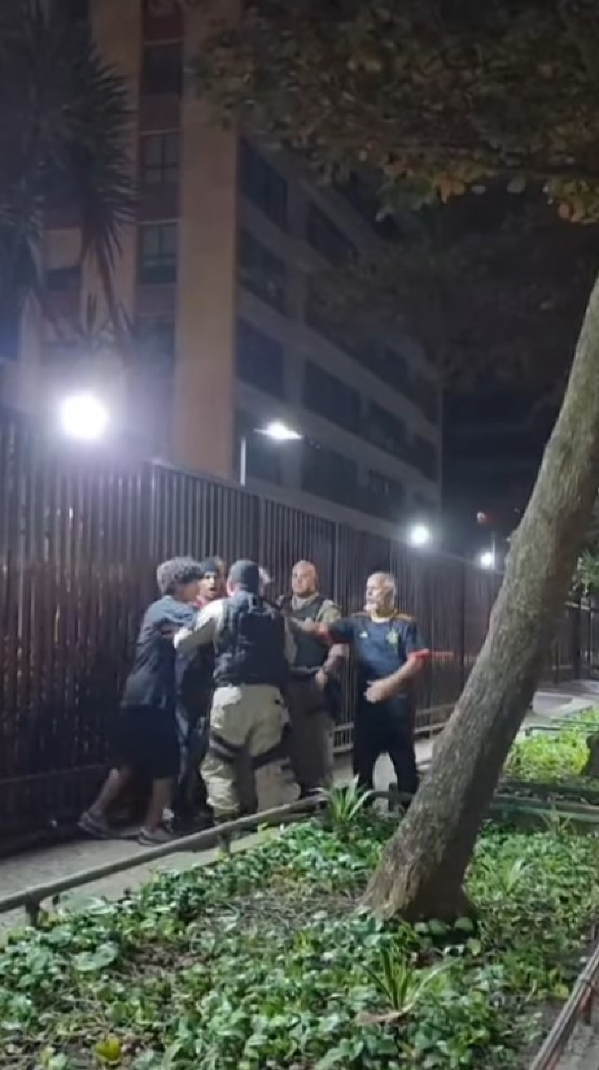 Agentes da GM seguram integrante de grupo pela camisa enquanto tentam apreender aparelho de som