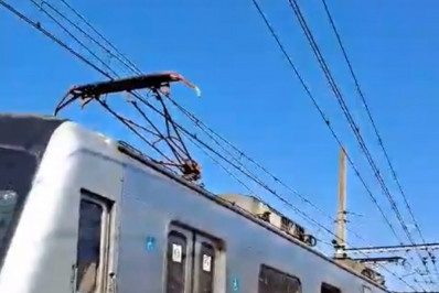 Passageiros caminham pelos trilhos após trem da SuperVia descarrilar próximo à Central do Brasil