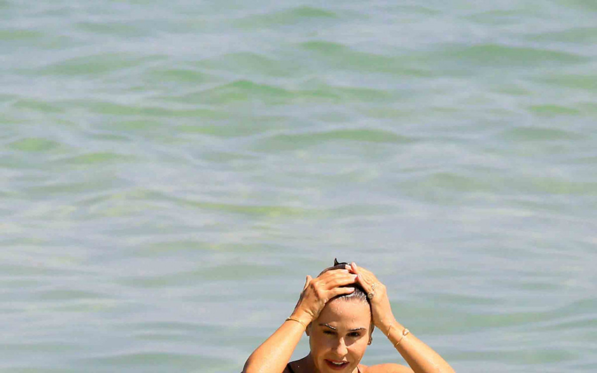 De mai&ocirc; preto, a atriz se refrescou no mar de Ipanema, na Zona Sul do Rio, e exibiu o corpo em forma
