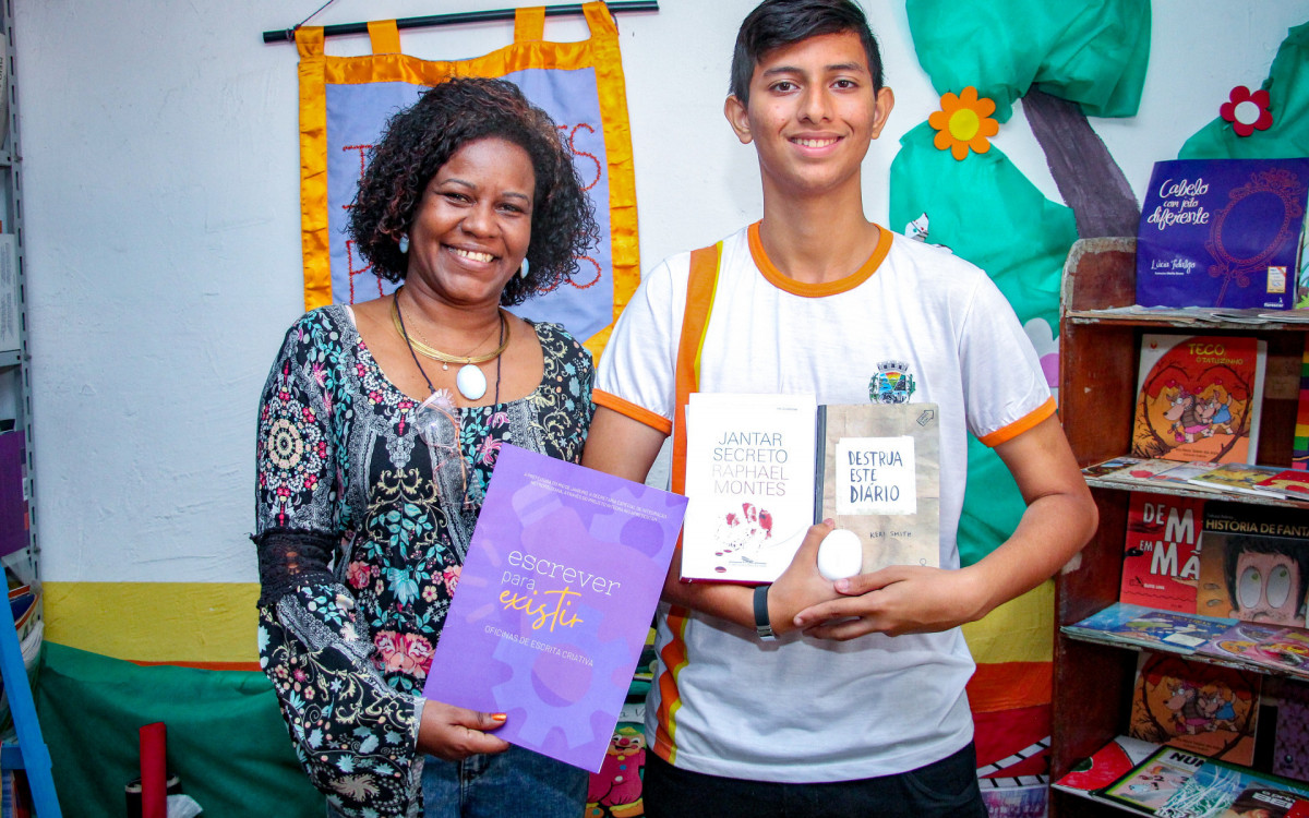 Carlos Daniel, ao lado da professora Márcia Joviano, exibe orgulhoso os prêmios conquistados