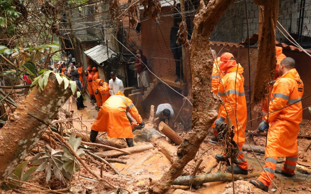 Profissionais da Comlurb fazem a limpeza de uma das áreas mais atingidas pela chuva na Rocinha