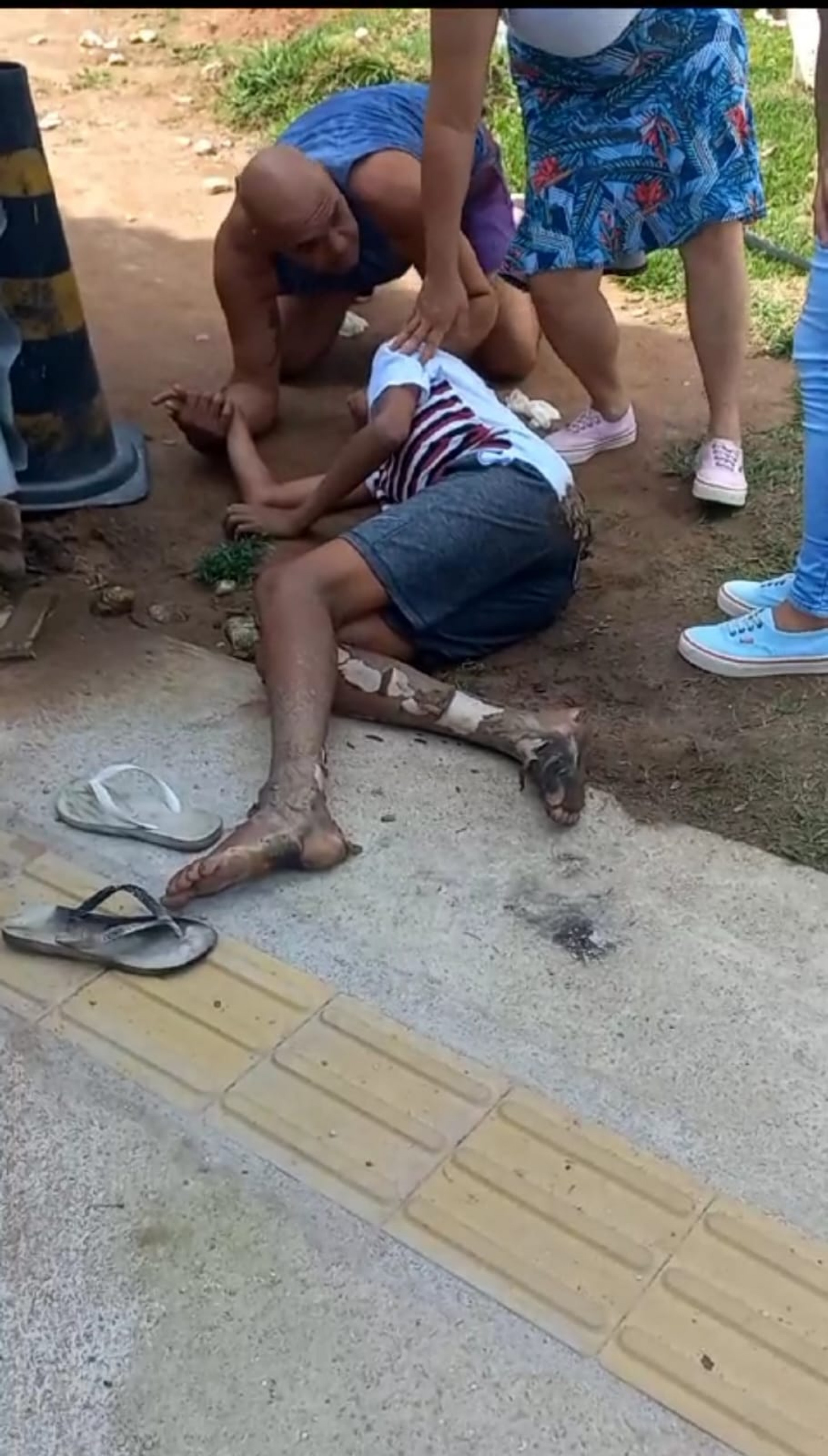 Adolescente caído no chão após ser atingido por um cabo de rede elétrica