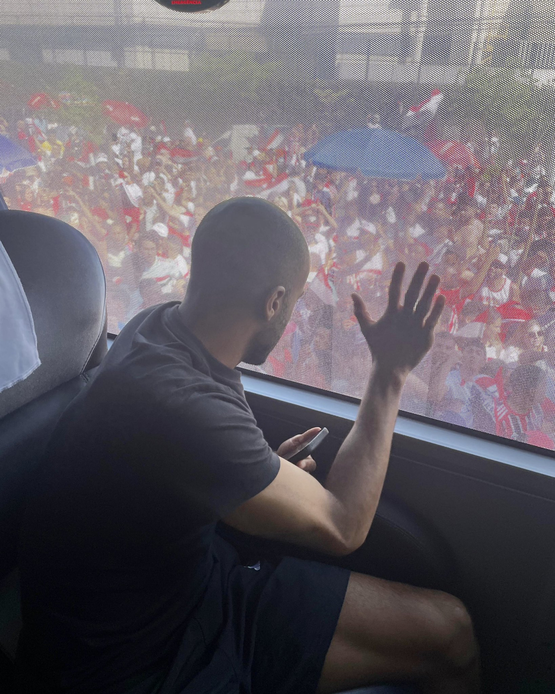 Dentro do ônibus, os jogadores do São Paulo acompanham a festa da torcida 