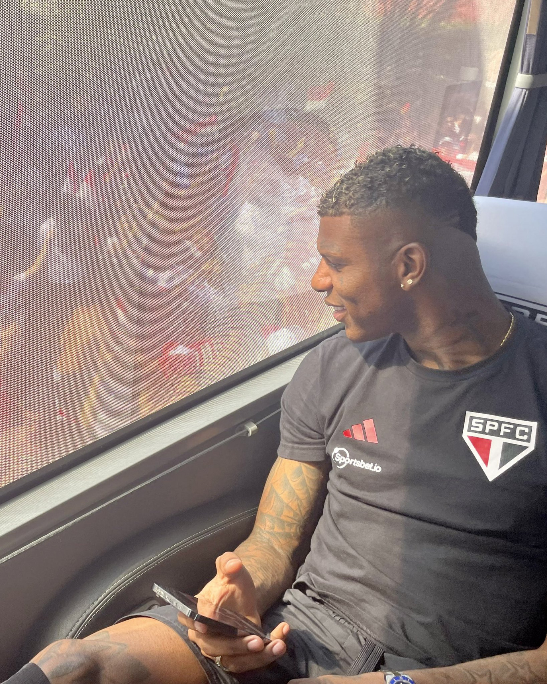 Dentro do ônibus, os jogadores do São Paulo acompanham a festa da torcida 