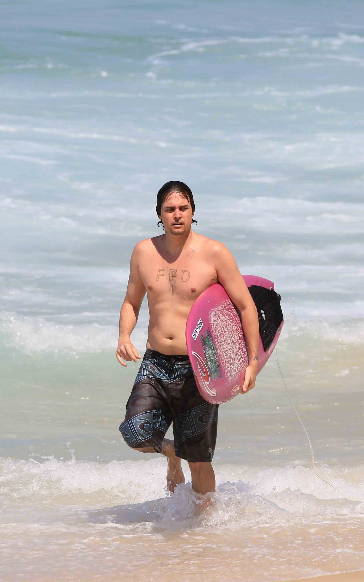 Felipe Dylon surfa na praia do Arpoador