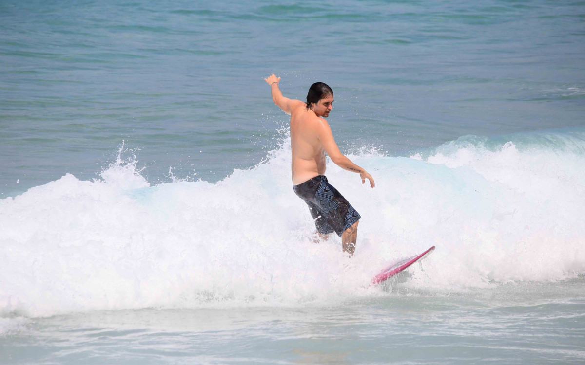 Felipe Dylon surfa na praia do Arpoador