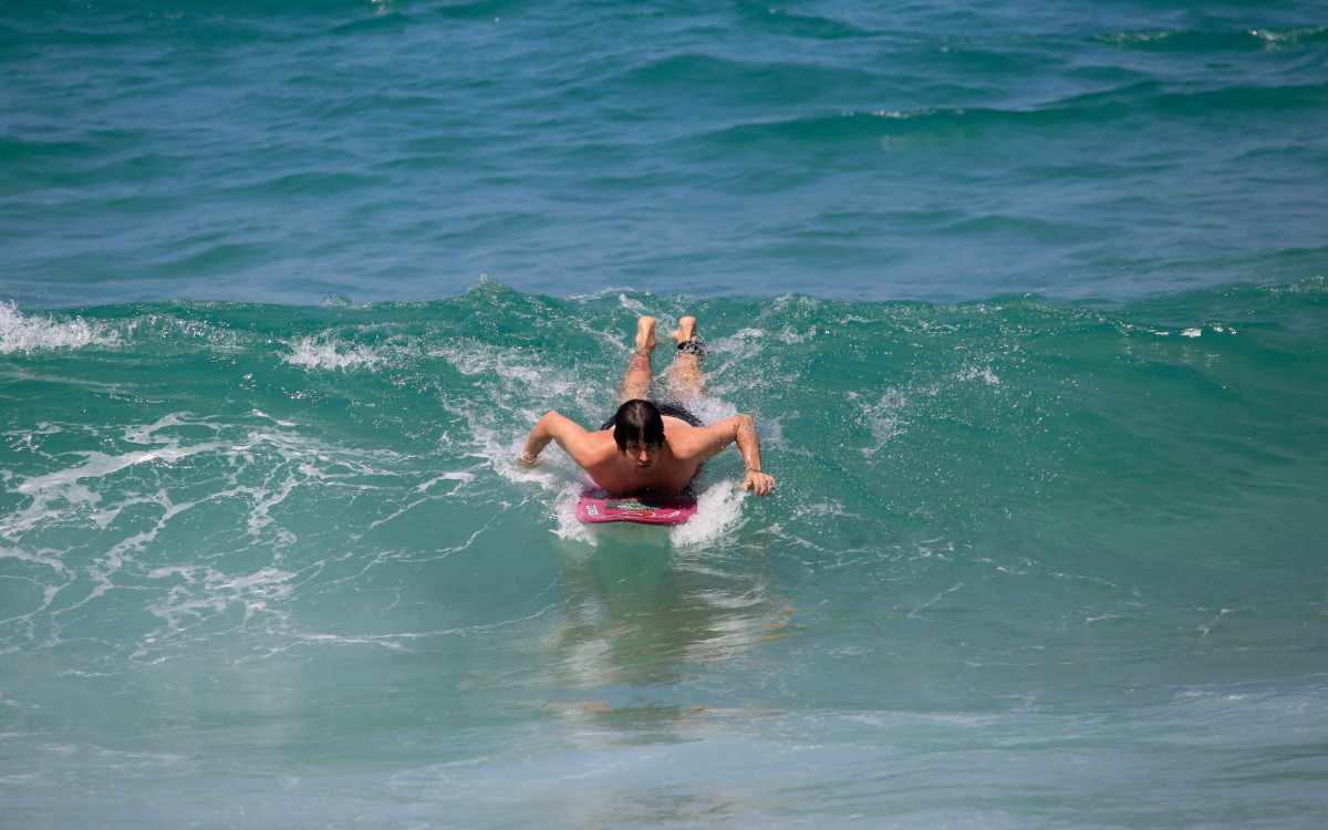 Felipe Dylon surfa na praia do Arpoador