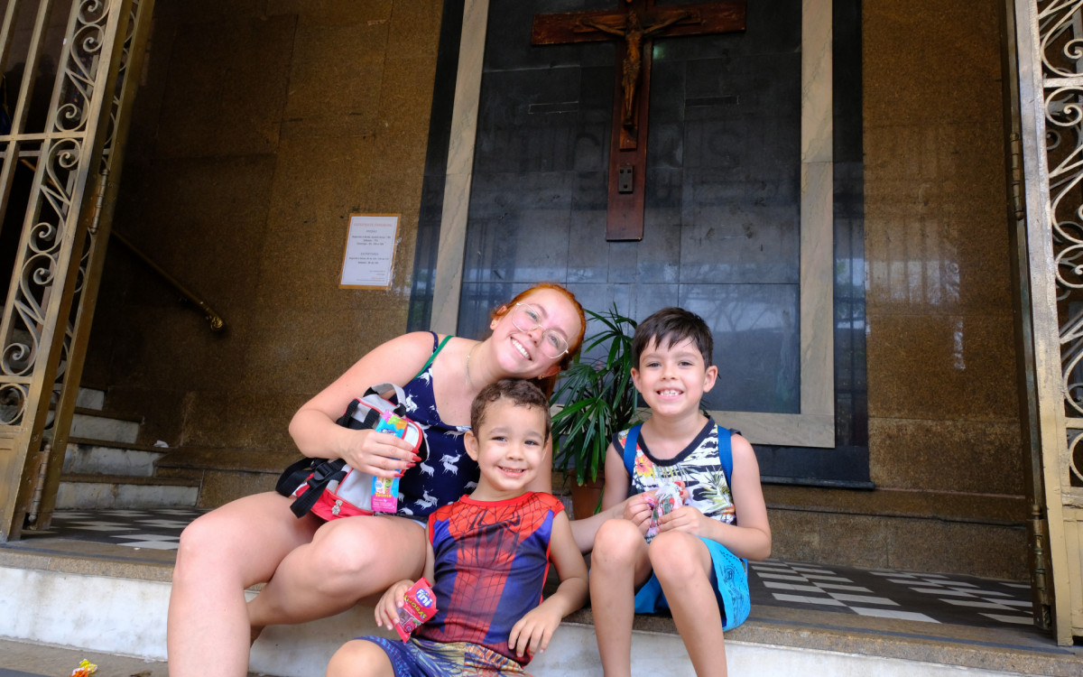 Andressa Ferreira com o filho e do sobrinho na Paróquia São Cosme e Damião no Andaraí - Pedro Ivo/ Agência O Dia