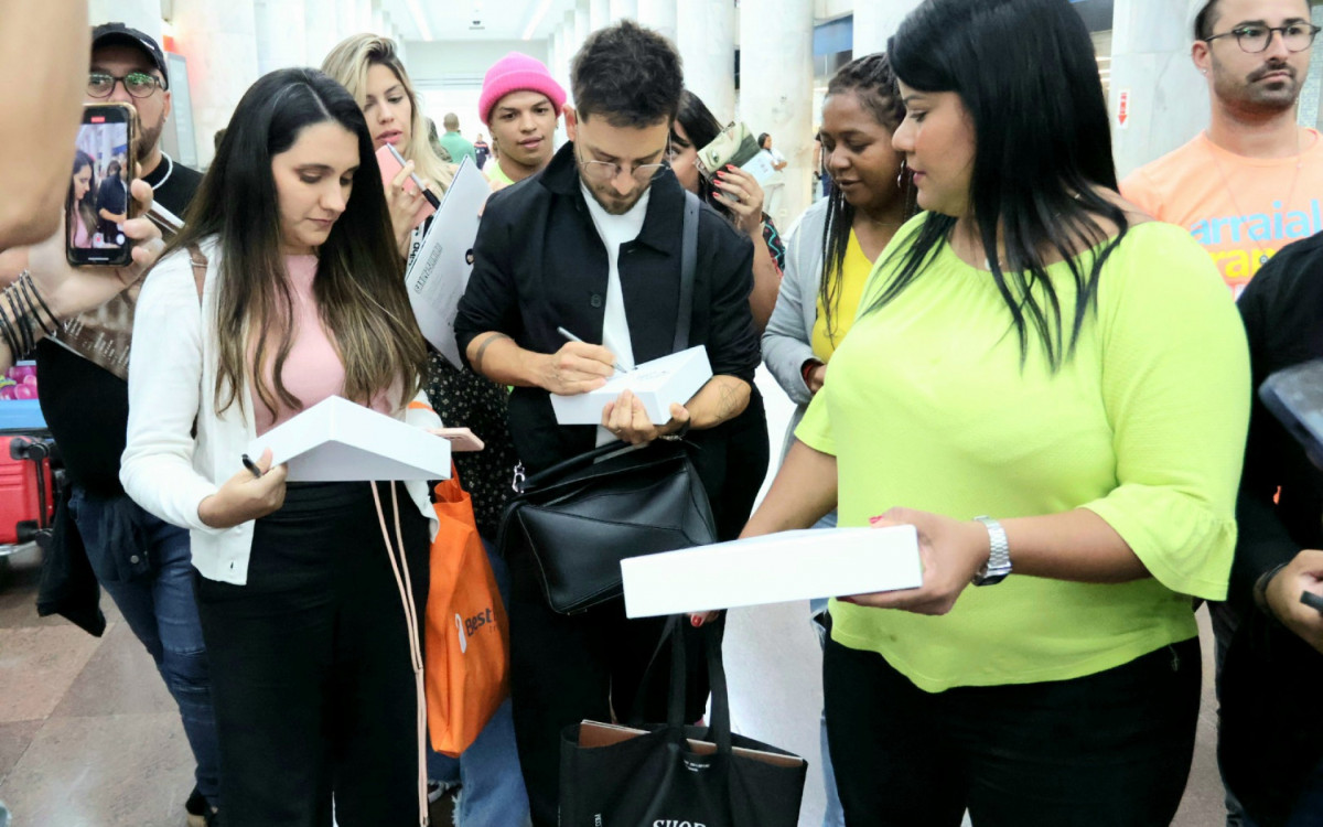 Junior Lima autografou álbuns da dupla Sandy & Junior ao ser abordado por fãs em aeroporto