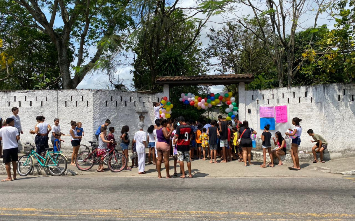 Do lado de fora do terreiro, as pessoas aguardam a distribuição de doces de Cosme e Damião