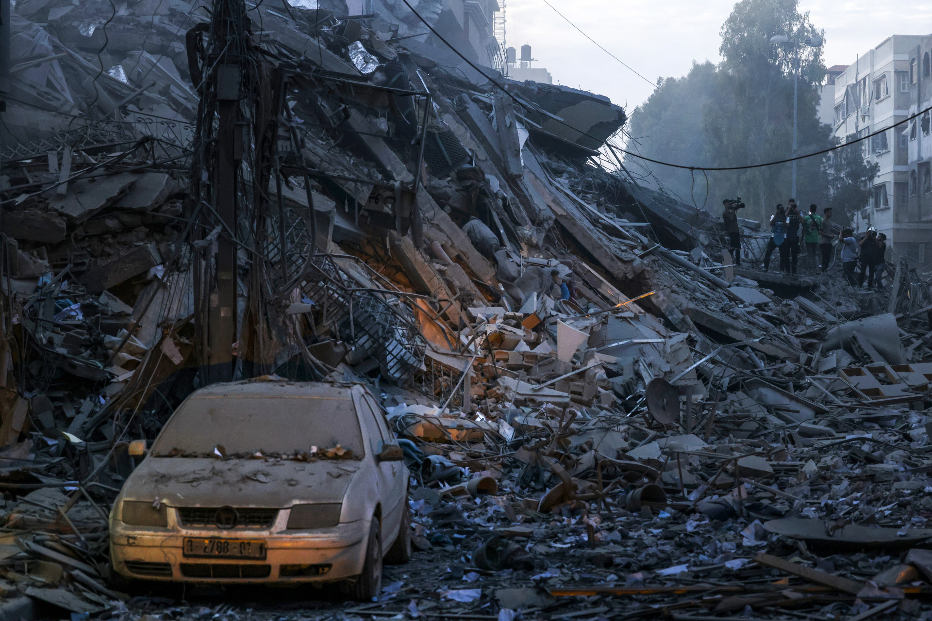 A damaged car sits amid the rubble of a tower destroyed in an Israeli air stike in Gaza City on October 7, 2023. Palestinian militants have begun a