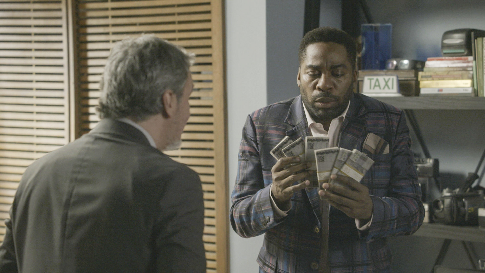 Roberto (Cassio Gabus Mendes) oferece dinheiro a Mário (Lázaro Ramos) - Divulgação / TV Globo