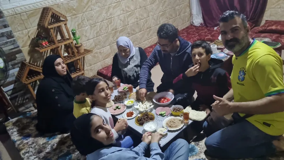 Brasileiros fazem refeição em casa na cidade palestina de Rafah, onde aguardam autorização para atravessar fronteira com Egito

 - Divulgação