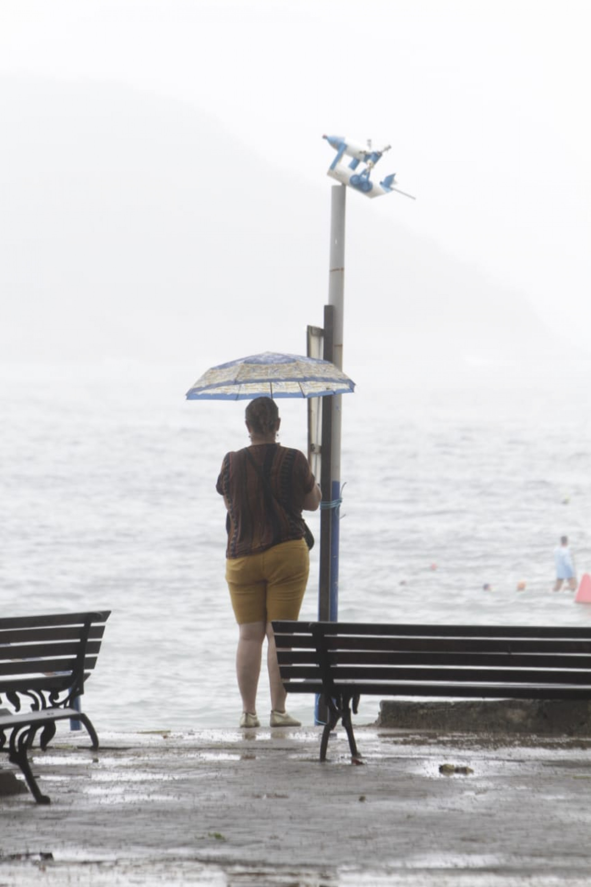 Apesar do tempo fechado, alguns cariocas passearam pela orla da Praia de Copacabana, neste sábado - Marcos Porto/Agência O DIA