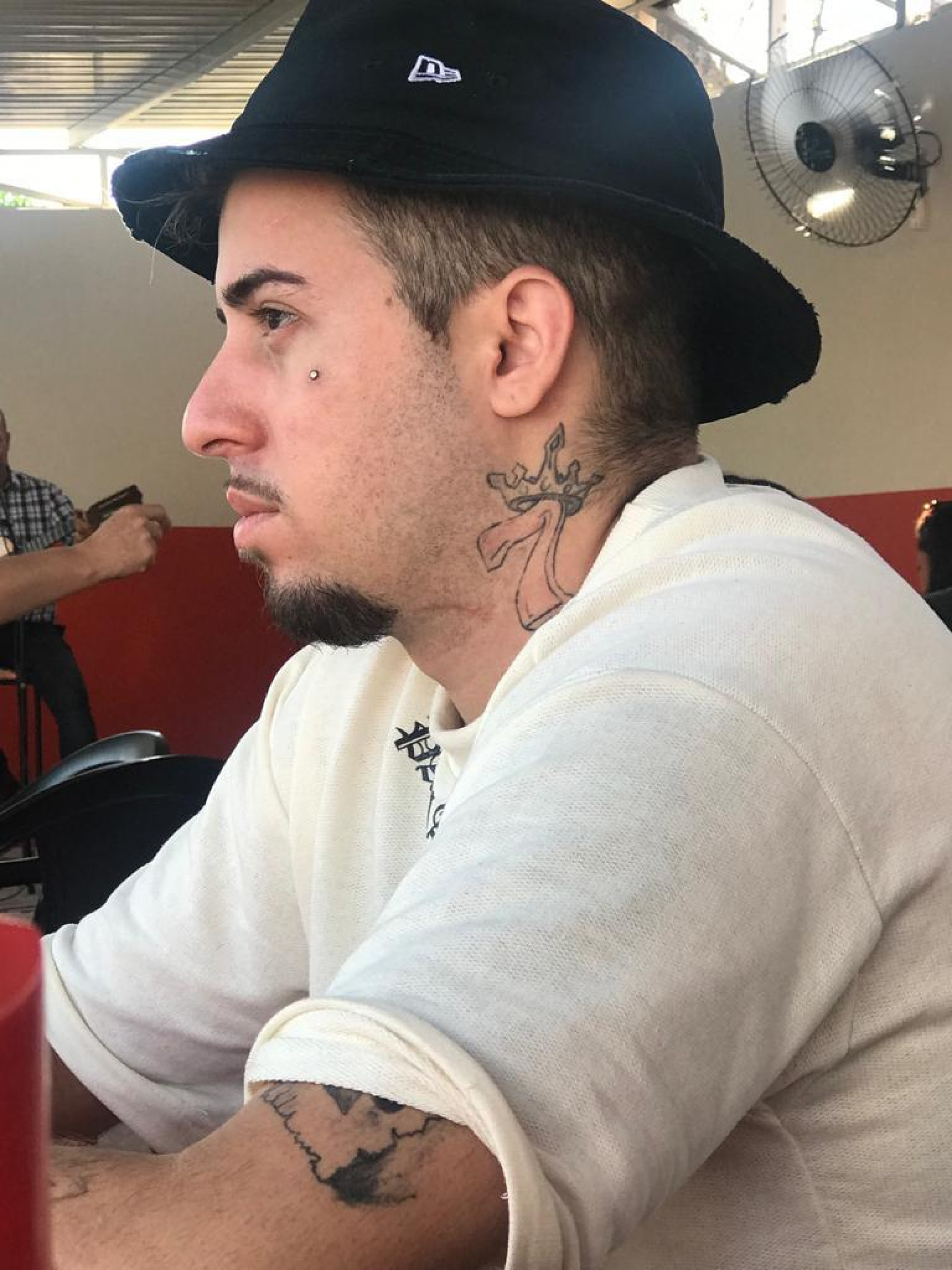 O jovem costumava usar chapéu e tem uma tatuagem no pescoço em alusão ao número 7 com a coroa de rei que carrega também um significado religioso de proteção  