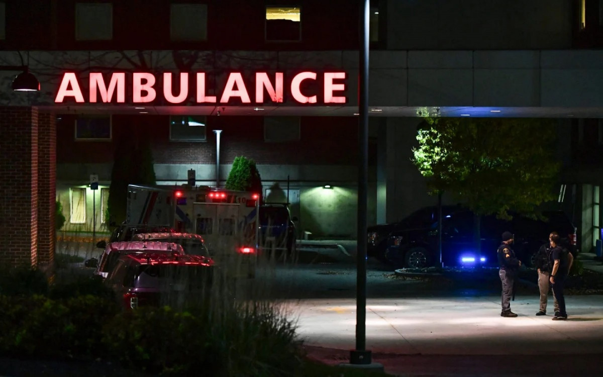 Policiais de Maine posicionados a frente do hospital que recebeu os feridos do tiroteio