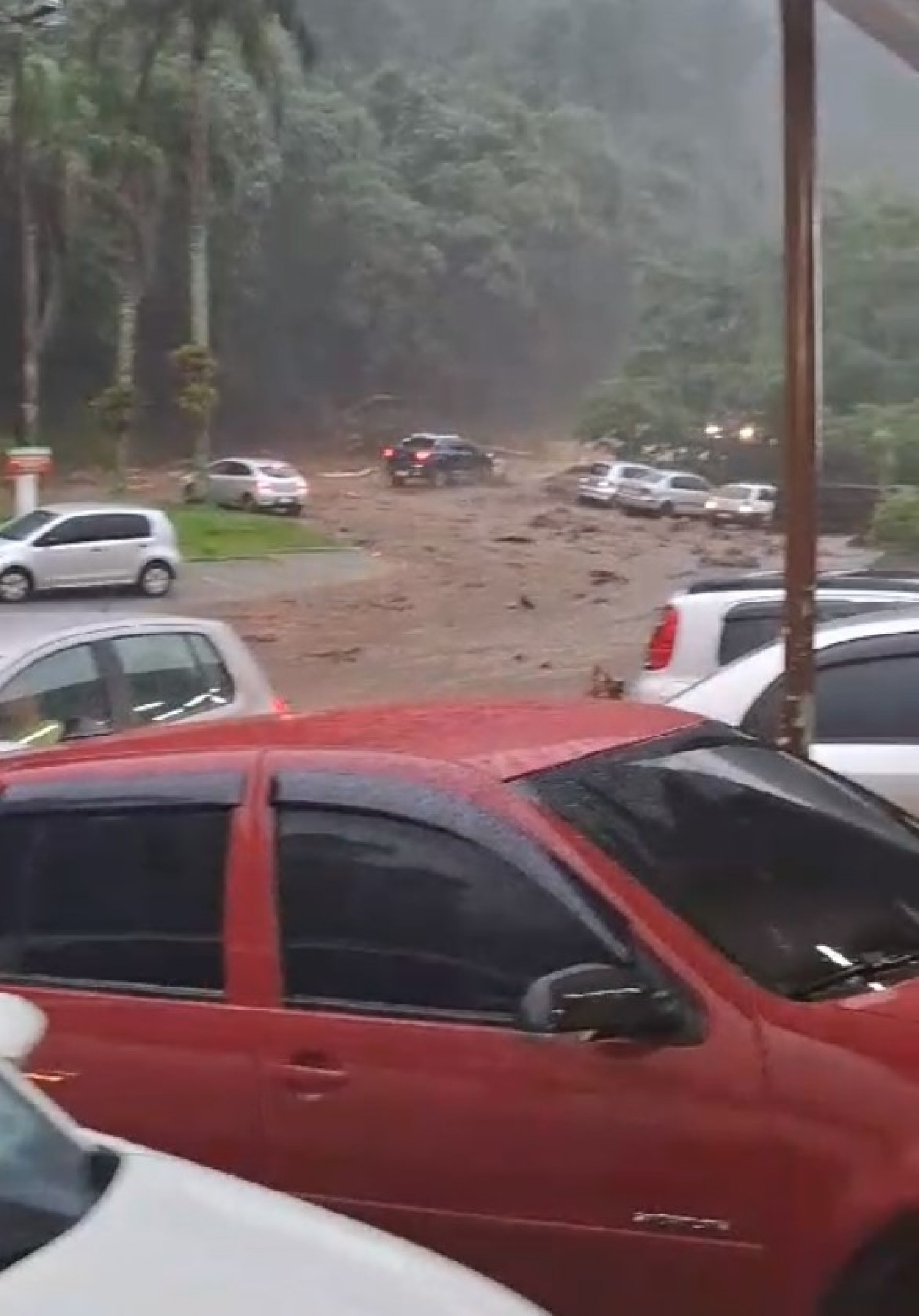 Chuva e lamaçal na serra de Guapimirim; motoristas esperam a chuva diminuir para seguir viagem