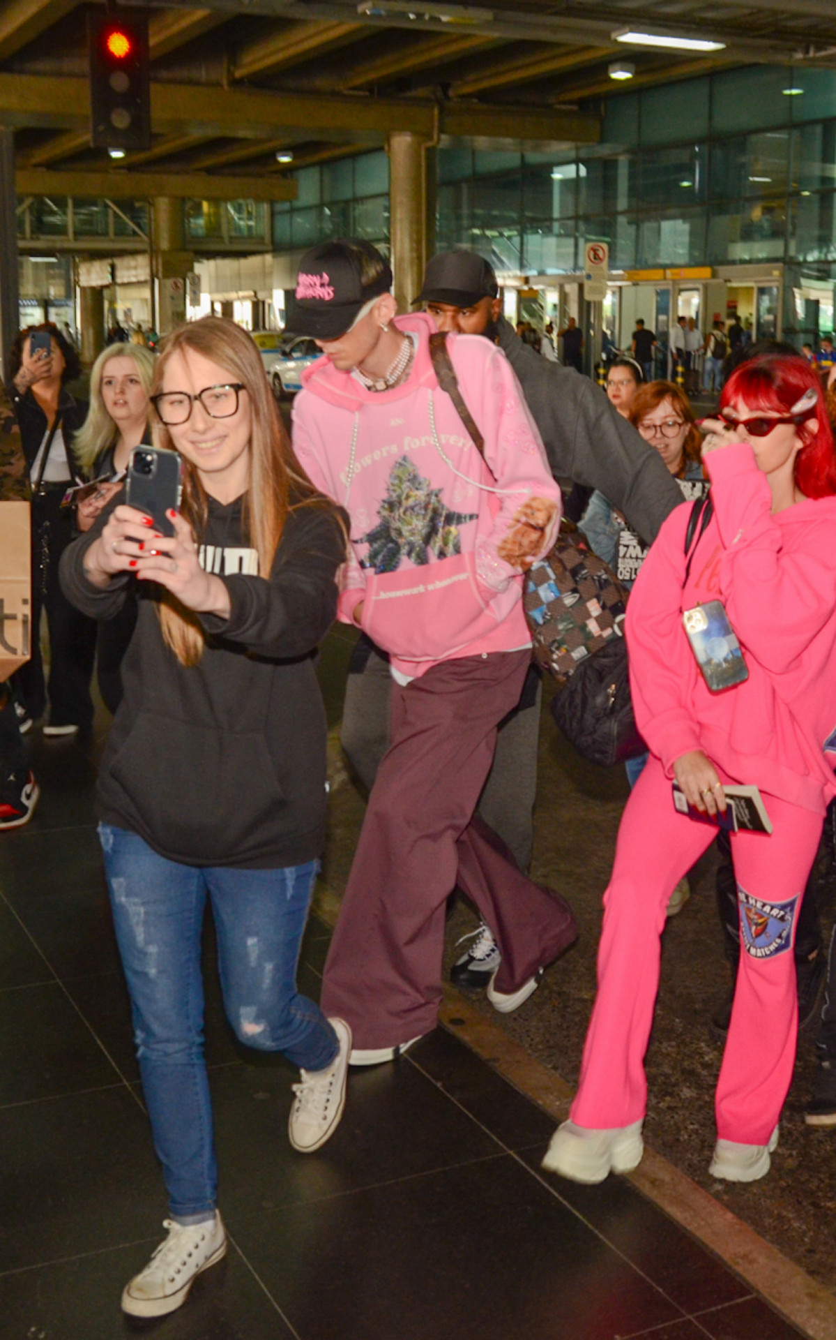 Megan Fox e o noivo, o rapper Machine Gun Kelly, no aeroporto de Guarulhos, em São Paulo
