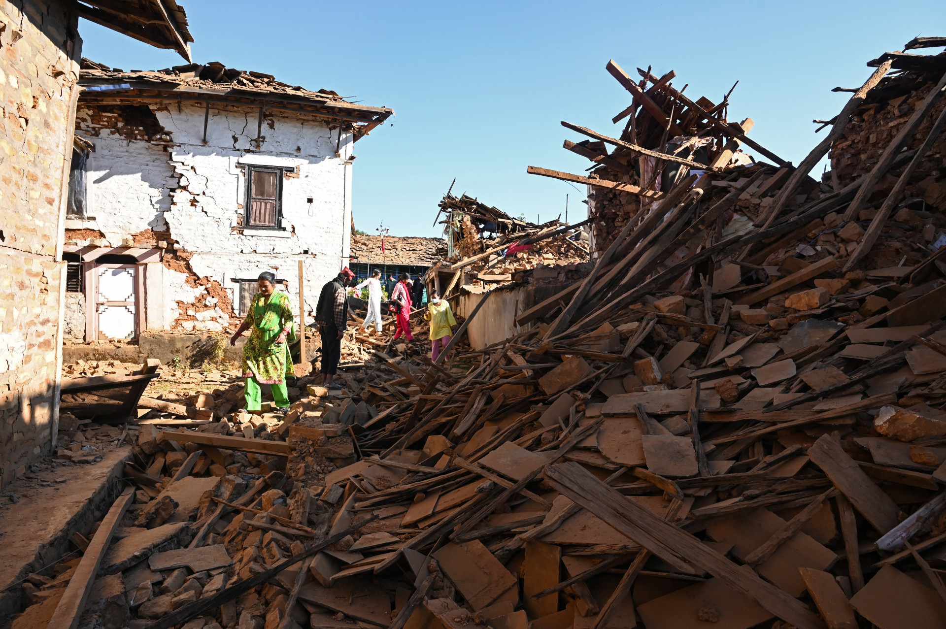 Pessoas em meios a destroços após terremoto que atingiu o Nepal na sexta-feira, 3 - PRAKASH MATHEMA / AFP