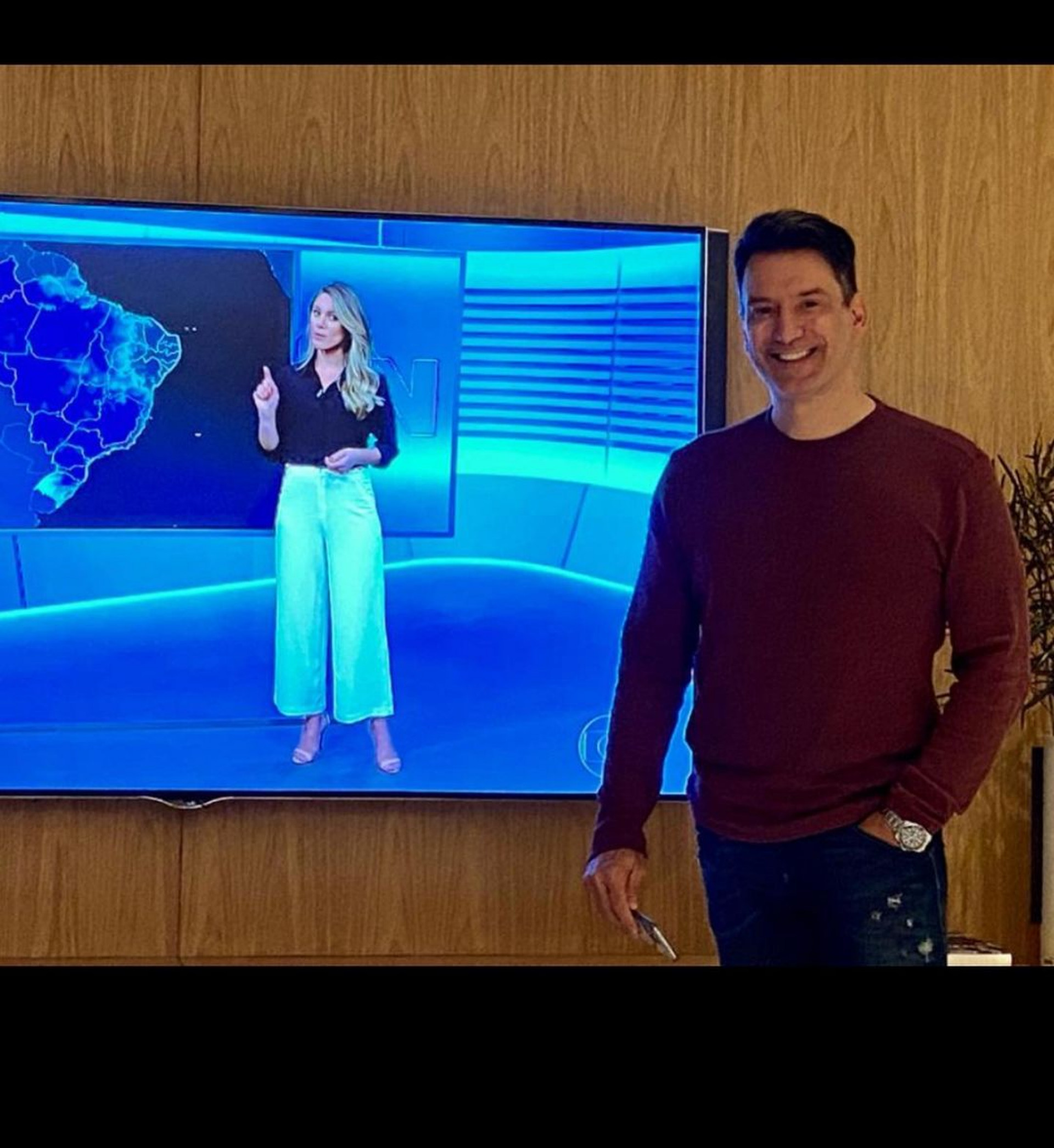 Luiz Carlos Jr. posa ao lado de Jacqueline Brazil na tela da Globo no 