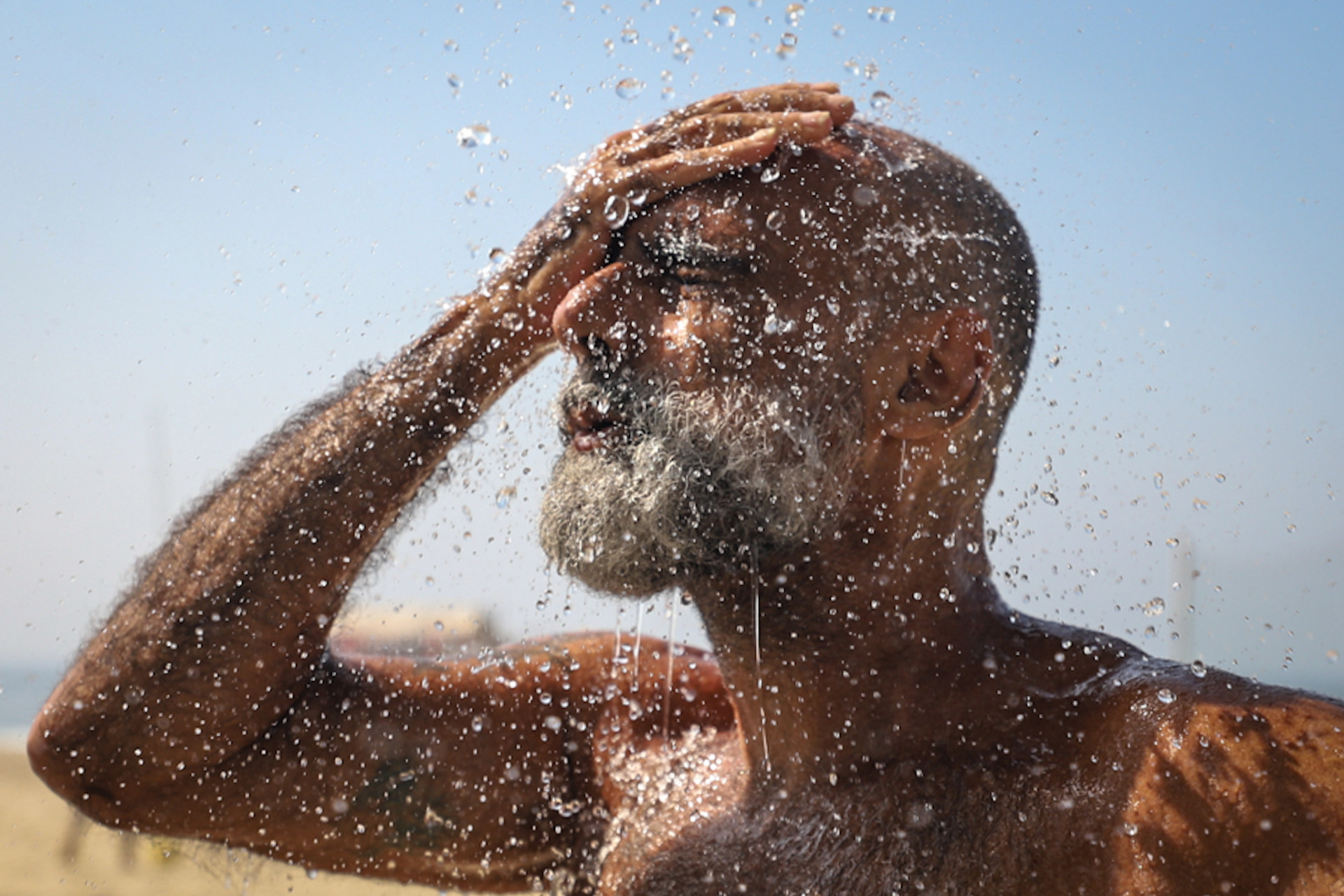Daniel Fontoura, 29, se banhando em chuveir&atilde;o na praia
 - Renan Areias / Ag&ecirc;ncia O Dia