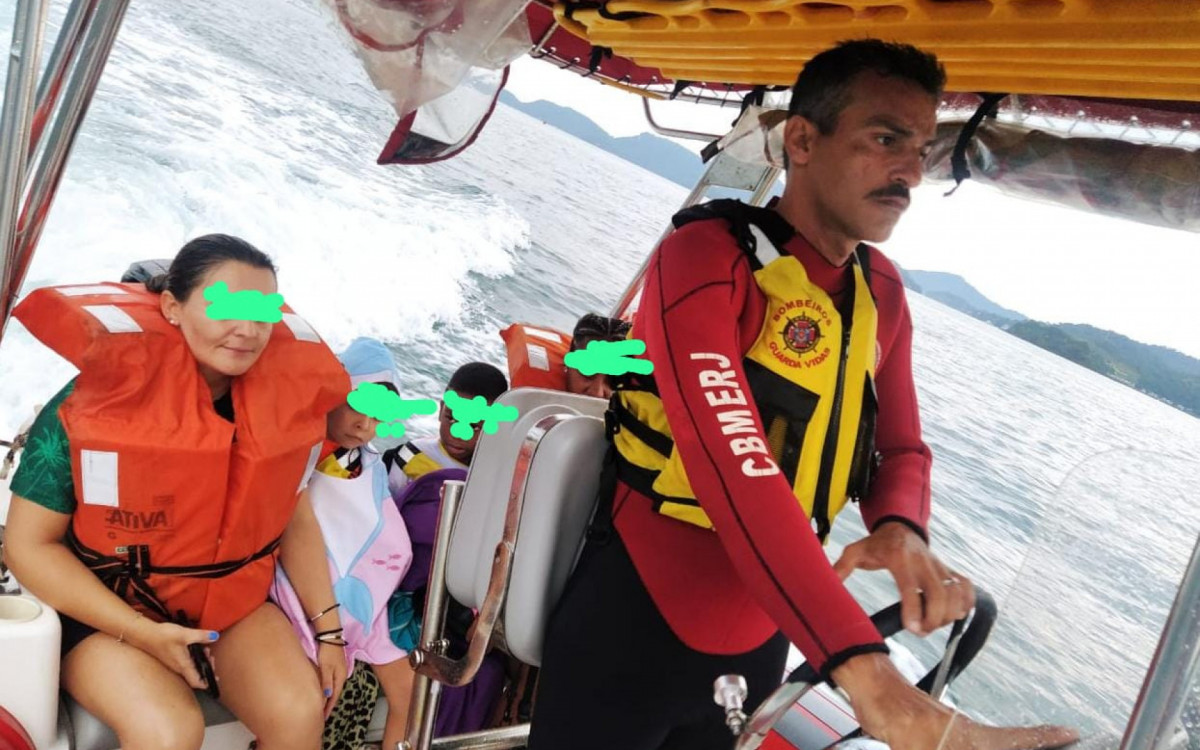 Momento da lancha do Corpo de Bombeiros chegando no cais com as quatro pessoas, sendo um adulto e três crianças resgatadas no mar em Angra