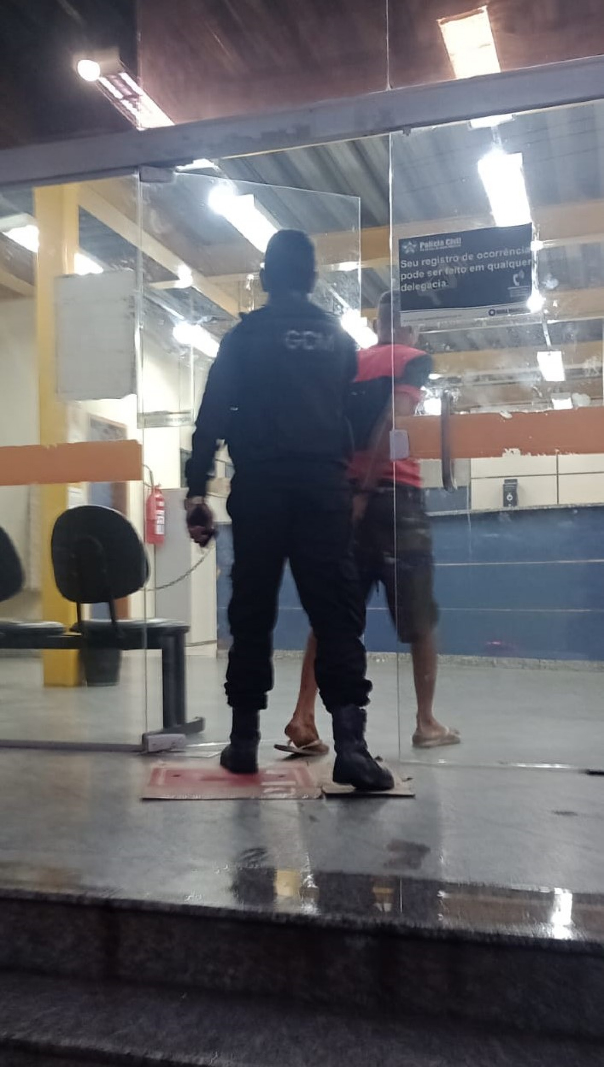 O agressor sendo conduzido pelo guarda civil municipal para o registro da ocorrência policial na 57ª DP