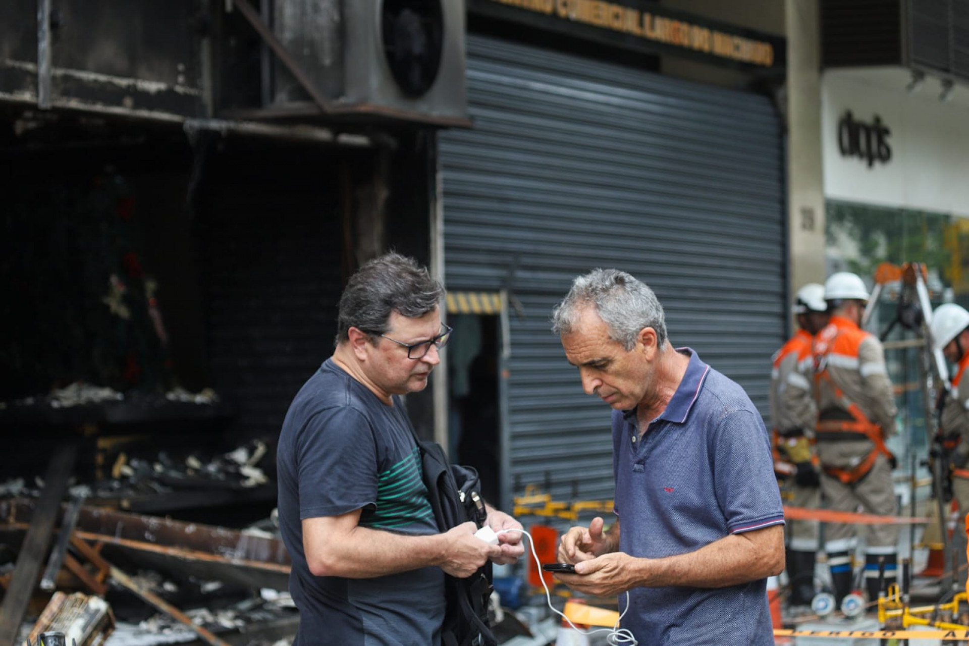 Gustavo Seijas (camisa preta) conversa com outro lojista que teve o estabelecimento incendiado - Renan Areias / Agência O Dia